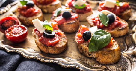 Fototapeta na wymiar Bruschetta toast with mozzarella tomatoes olives