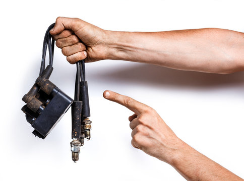 Auto Mechanic With Old High-voltage Wires, Spark Plugs And Ignition Coil. Isolated On White Background. Old Car Parts In The Hand.