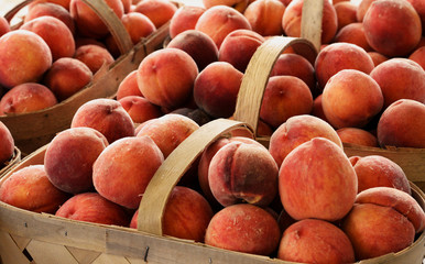 Fresh peaches in wooden baskets.