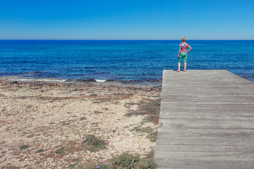 Kobieta stojąca na drewnianym pomoście nad morzem, Paphos, Cypr © Agnieszka