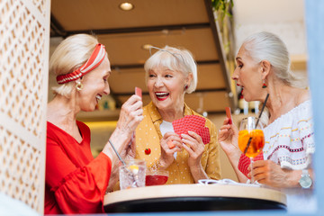 Family meeting. Positive cheerful sisters laughing while playing cards together