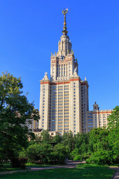 Building of Moscow State University (MSU) against blue sky and green trees in the park in sunny summer evening
