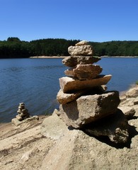 Cairns ensoleillés sur le rivage d'un lac du Morvan