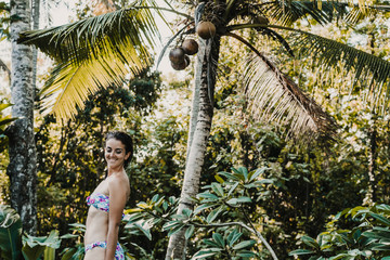 .Young and pretty woman enjoying her vacation in Ubud, in the Bali island, Indonesia. A summer afternoon in the pool with a tropical background. Relaxed and happy attitude. Lifestyle.