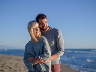 Fototapeta na wymiar Loving young couple on a beach at autumn sunny day