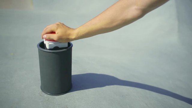 A red game show buzzer standing on a concrete floor, is pressed by a young freerunner. 
