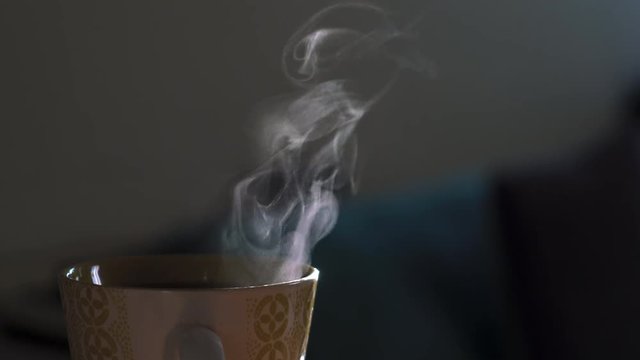 Humo blanco de taza con caf&eacute; en fondo oscuro