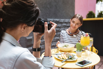 Photo of woman. Professional photographer wearing jeans jacket making photo of beautiful woman
