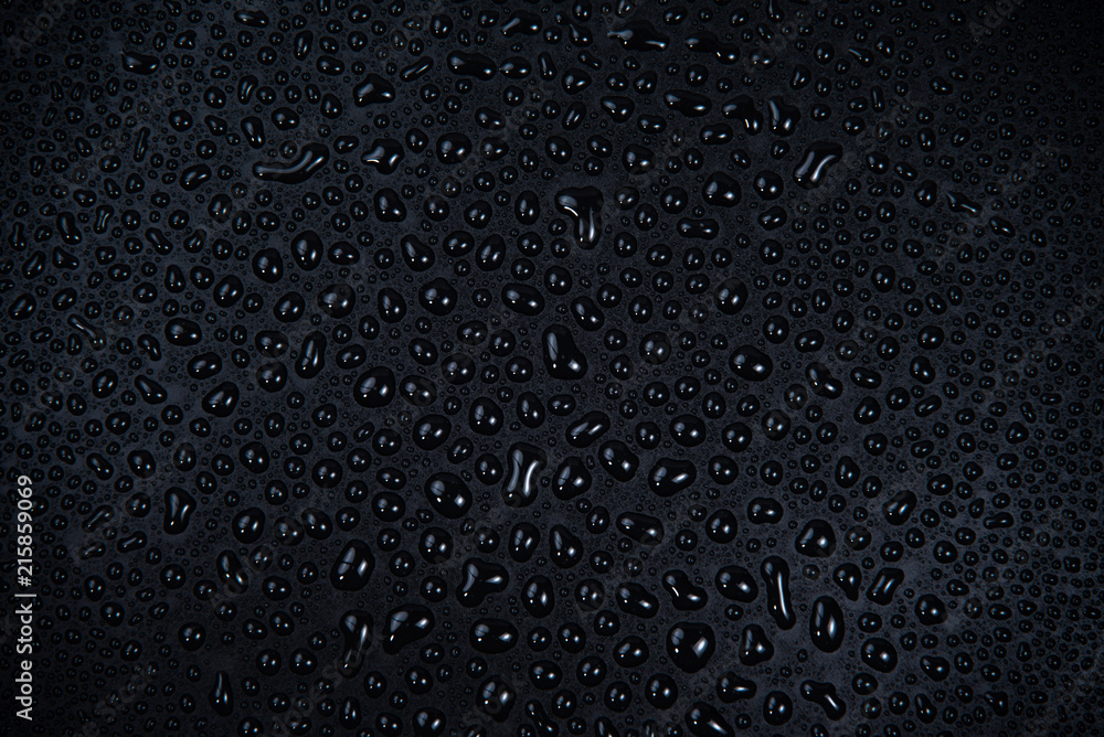 Wall mural Drops of water on black background.