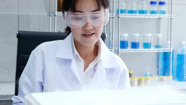 Asian female scientist holding sample experiment in hand at laboratory. People with science concept. 4K Resolution