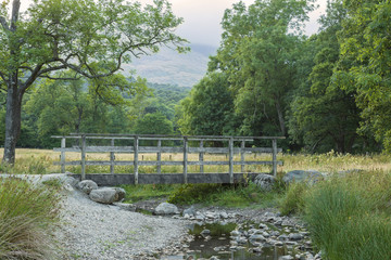 Fototapeta na wymiar Footbridge / An image of an old footbridge over a shallow stream in the Lake District, Cumbria, England, UK