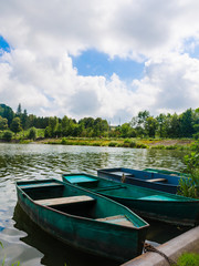 Wooden pier or jetty and a boat on lake sunset and sky reflection water.