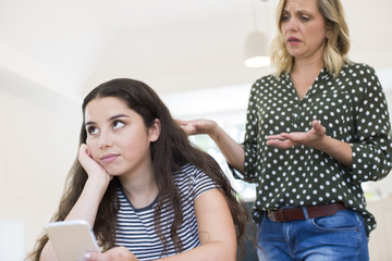 Mother Arguing With Teenage Daughter Over Use Of Mobile Phone