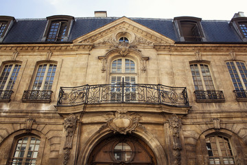 Fototapeta na wymiar View of a traditional, historical building in Paris showing Parisian / French architectural style. It is a sunny day in spring. 3rd arrondissement