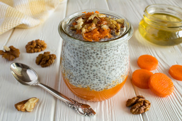 Pudding with chia,carrot,walnuts  and honey on the white  wooden background