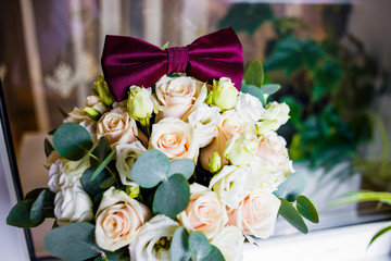Wedding bouquet of white and pink roses with a burgundy butterfly