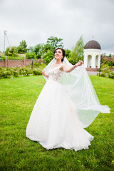 Fototapeta premium The bride in a white dress standing in the park