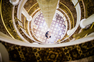 Loving couple hugging under the chandelier in the lobby