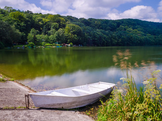 Obraz premium Wooden pier or jetty and a boat on lake sunset and sky reflection water.