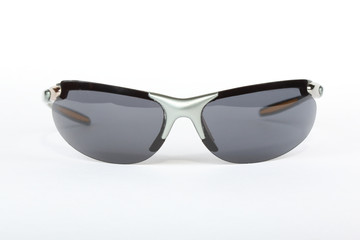 Old sport sunglasses with silver plastic frame and a gray glass on a white background