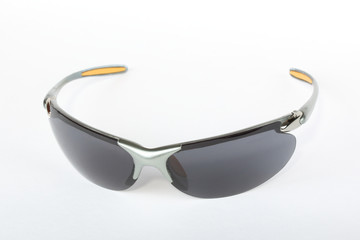 Old sport sunglasses with silver plastic frame and a gray glass on a white background