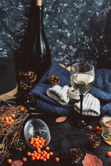  wine in glasses ,red berries,bumps and autumn branches on dark table. Autumn or Winter concept.
