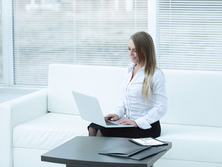 young business woman with laptop on the background of the office