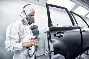 Painting the car in black color in the paint chamber on the service..