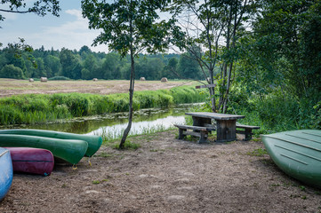Canoes stopped at the riverbank. Picnic place next to the river. Soomaa National Park. Estonia. Baltic. Soft focus.