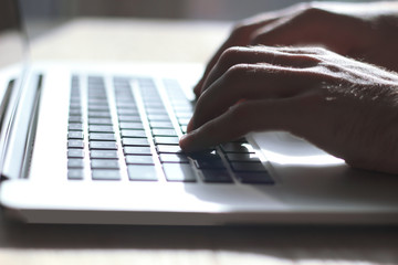 close up. male typing text on laptop keyboard