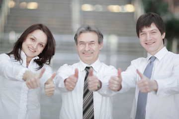 closeup . successful business team holding up a thumbs up