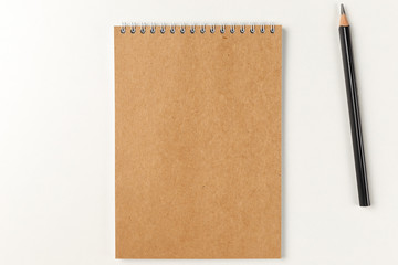 Blank notebook with pencil on white background. Workplace. Copy space. Minimal concept. Top view. Flat lay