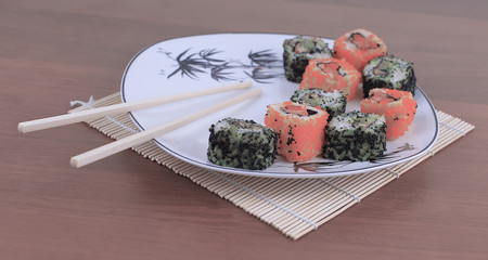 close-up of sushi and chopsticks on a white plate