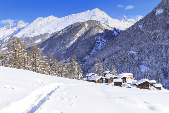 A trail in the snow leads to the traditional huts of Blatten, Zermatt, Canton of Valais (Wallis)