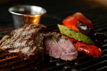 Grilled meat with vegetables and sauce, on the grill
