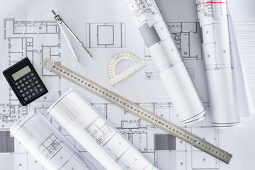 top view of architect blueprints, ruler, protractor, calculator and divider