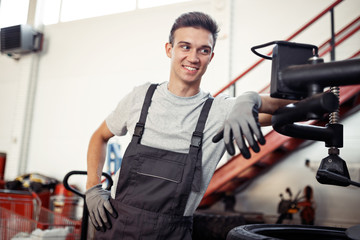 A man is at his work in a car repair service during a break