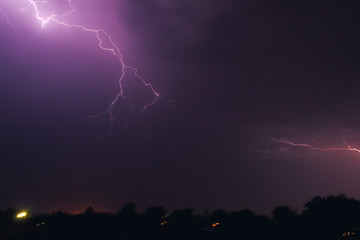 bright flash of lightning illuminated the night sky and dyed clouds in a blue violet color