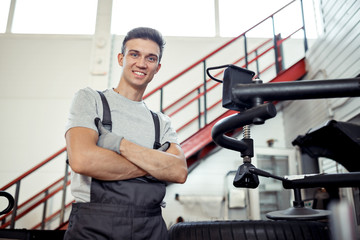 A young attractive mechanic is smiling while having a rest