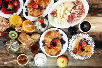 Fototapeta na wymiar breakfast on table with waffles, croissants, coffe and juice.