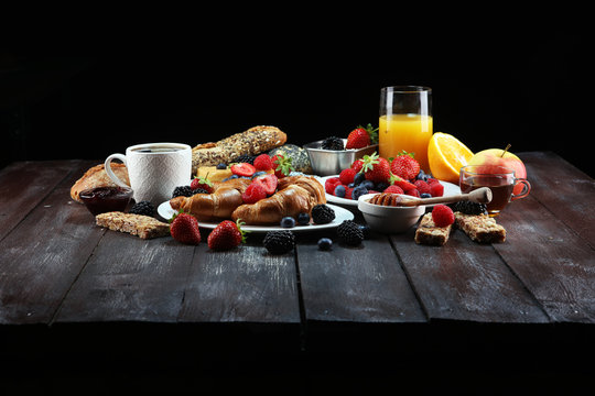 breakfast on table with waffles, croissants, coffe and juice.
