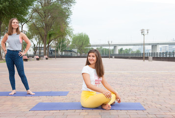 Beautiful woman doing Vriksasana pose on yoga class