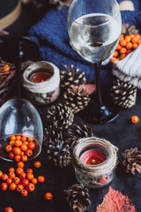  wine in glasses ,red berries,bumps and autumn branches on dark table. Autumn or Winter concept.