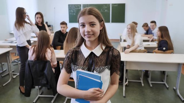 Portrait of a young Russian high school graduate against the background of her class.