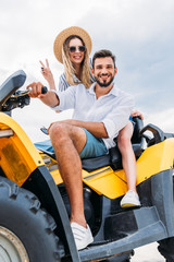 Fototapeta na wymiar happy young couple sitting on ATV and looking at camera