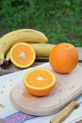 Orange juicy oranges on a wooden background. Whole and cut in half. Healthy food. Fresh organic fruits. Source of vitamin C. Copy space