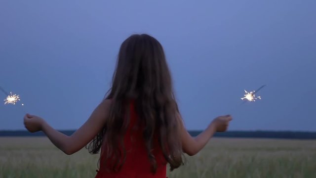 Portrait of a girl with sparklers in their hands at evening.
