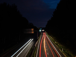 Fototapeta na wymiar Light trails of driving cars under the bridge at night