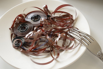 the tangled magnetic tape is on a porcelain plate with a fork
