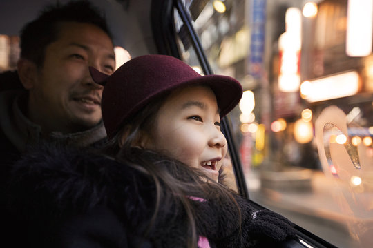 Father and daughter look out taxi window